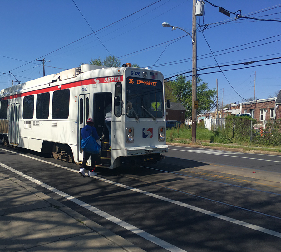A person boarding a trolley in the Kingsessing neighborhood of Southwest Philadelphia. Credit: Cristina Arlt