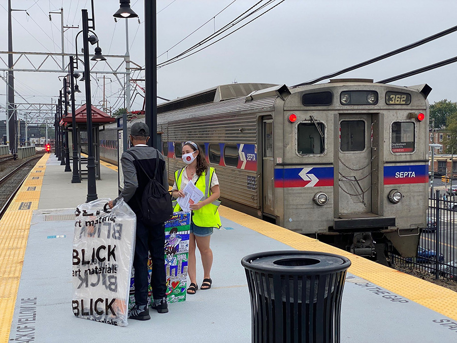 Two people on train platform with train in background. Credit: SEPTA