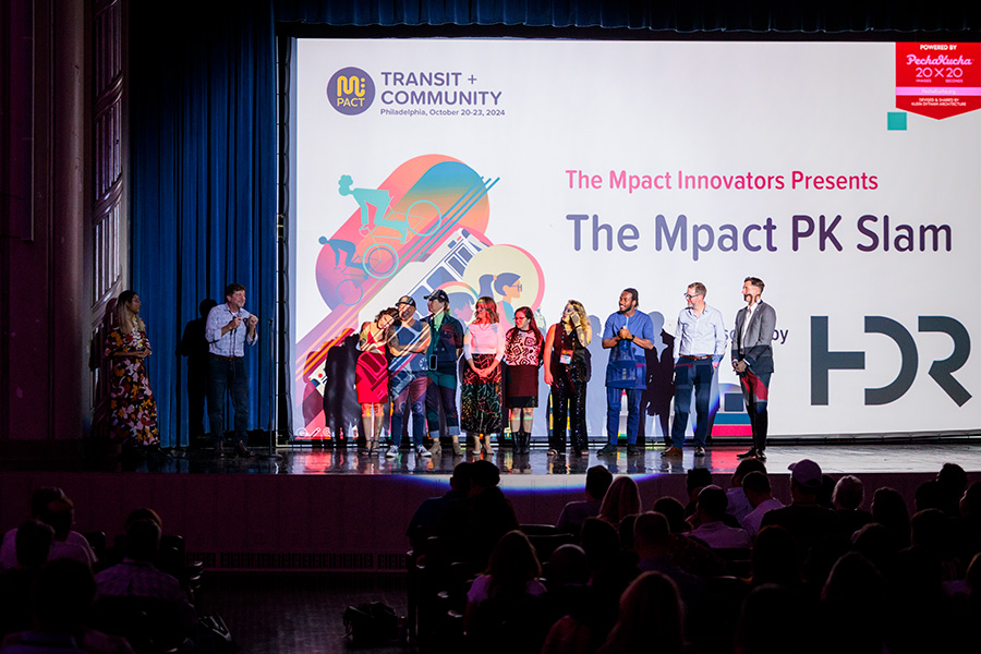 A bunch of people on a stage with a colorful backdrop